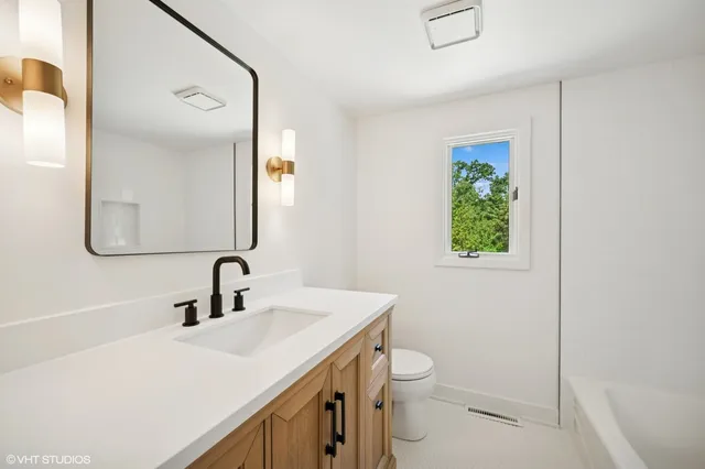 a bathroom with a sink a toilet and a mirror