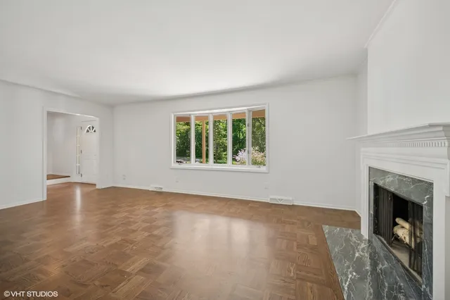 a view of an empty room with a window and fireplace