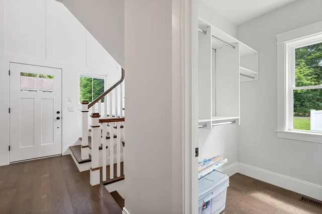 an entryway with wooden floor and windows