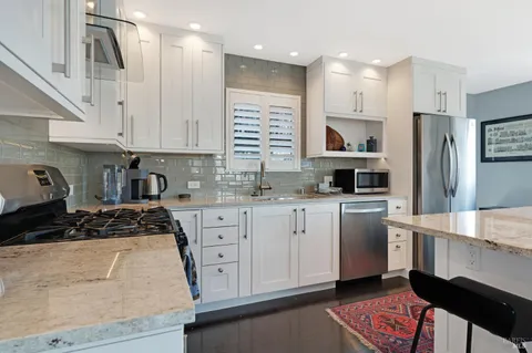 a kitchen with a refrigerator and a stove top oven