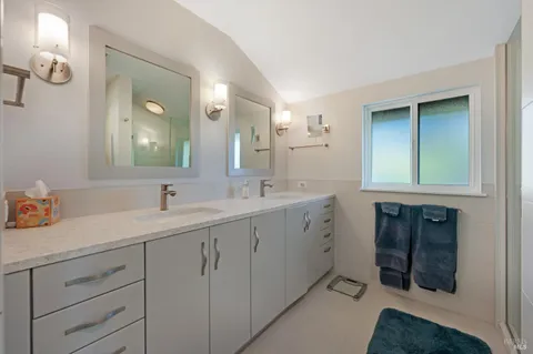 a bathroom with double sink and a mirror