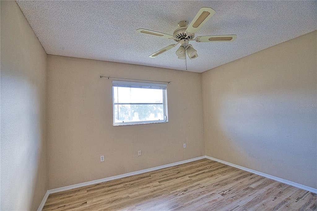 5847 Buchanan Road Venice, FL 34293 - Photo 37 of 47 an empty room with wooden floor fan and windows