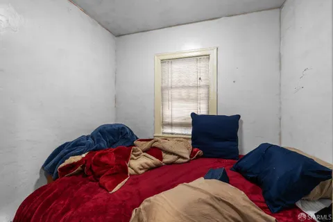 a bedroom with a bed and two window