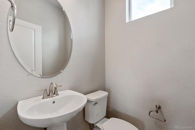 a bathroom with a sink mirror and toilet