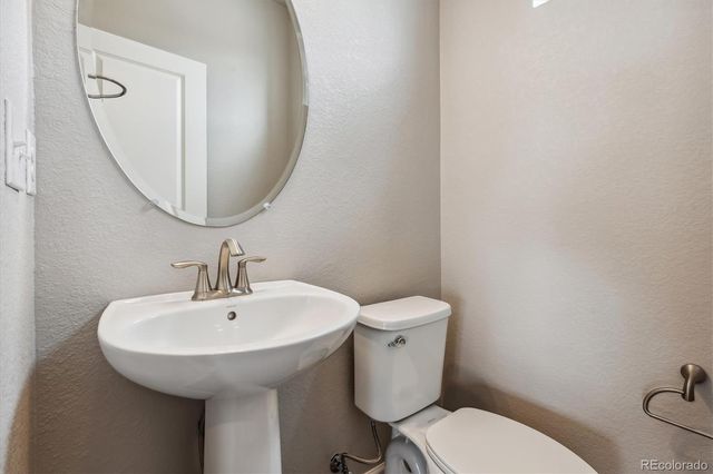 a bathroom with a toilet a sink and a mirror