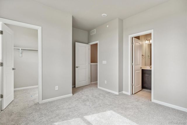 an empty room with closet and a bathroom