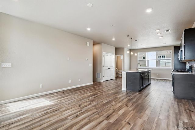 a view of kitchen with cabinets and refrigerator