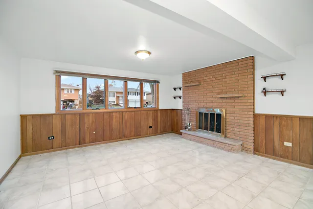 a view of an empty room with a fireplace and cabinet