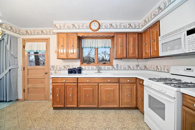 a kitchen with stainless steel appliances granite countertop a stove a sink and a microwave