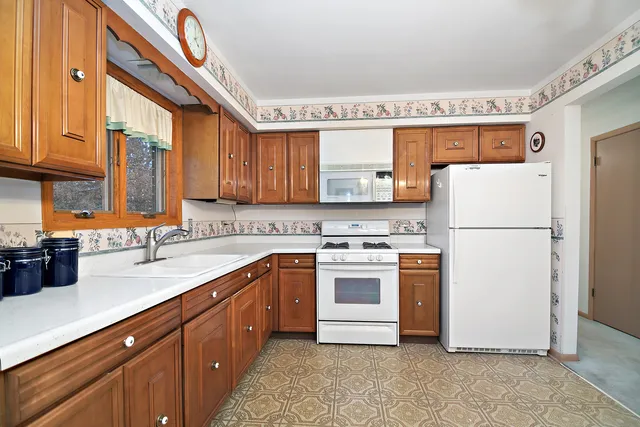a kitchen with a sink a refrigerator and cabinets