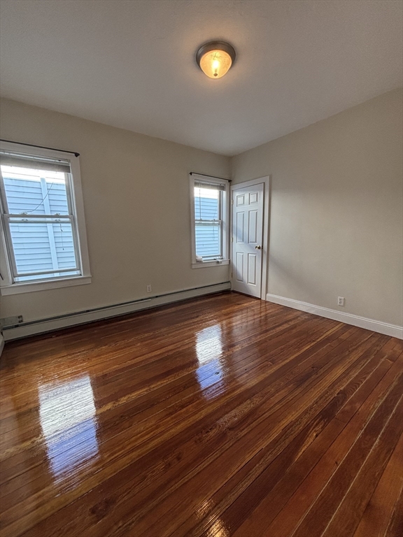 47 Middle Street Boston, MA 02127 - Photo 2 of 12 an empty room with wooden floor and windows