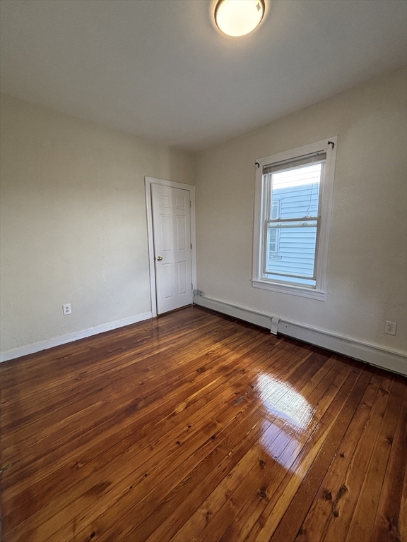 47 Middle Street Boston, MA 02127 - Photo 3 of 12 an empty room with wooden floor and windows