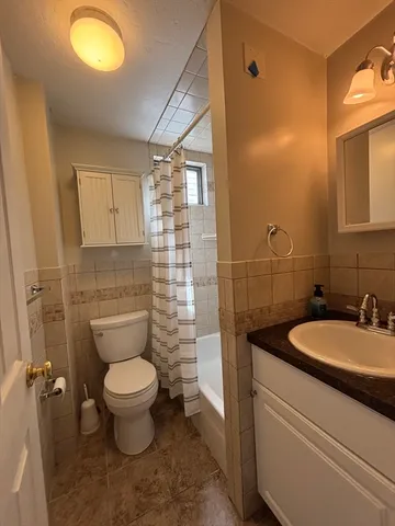 a bathroom with a granite countertop toilet sink and mirror
