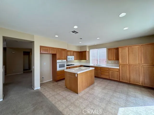 a kitchen with granite countertop a stove top oven and cabinets