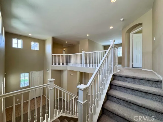 a view of staircase with wooden floor and fan