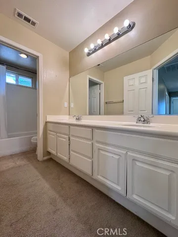a spacious bathroom with double sink a mirror and a