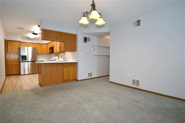 an empty room with a window and chandelier