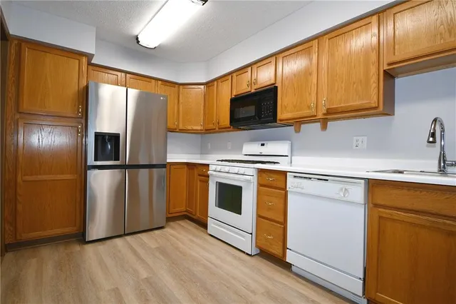 a kitchen with stainless steel appliances granite countertop a stove a sink and a microwave