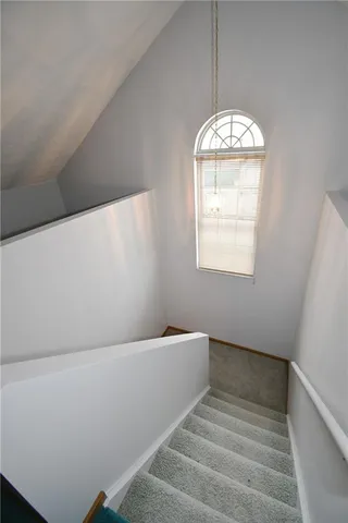 an empty room with a ceiling fan and carpet