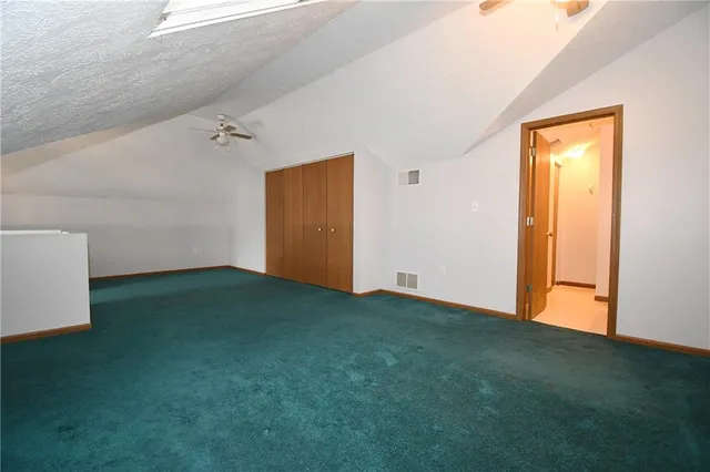an empty room with a ceiling fan and wooden floor