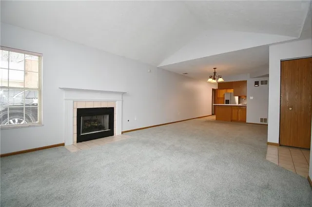 an empty room with a kitchen and a window