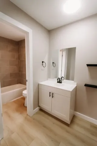 a bathroom with a bathtub a sink a toilet and a mirror