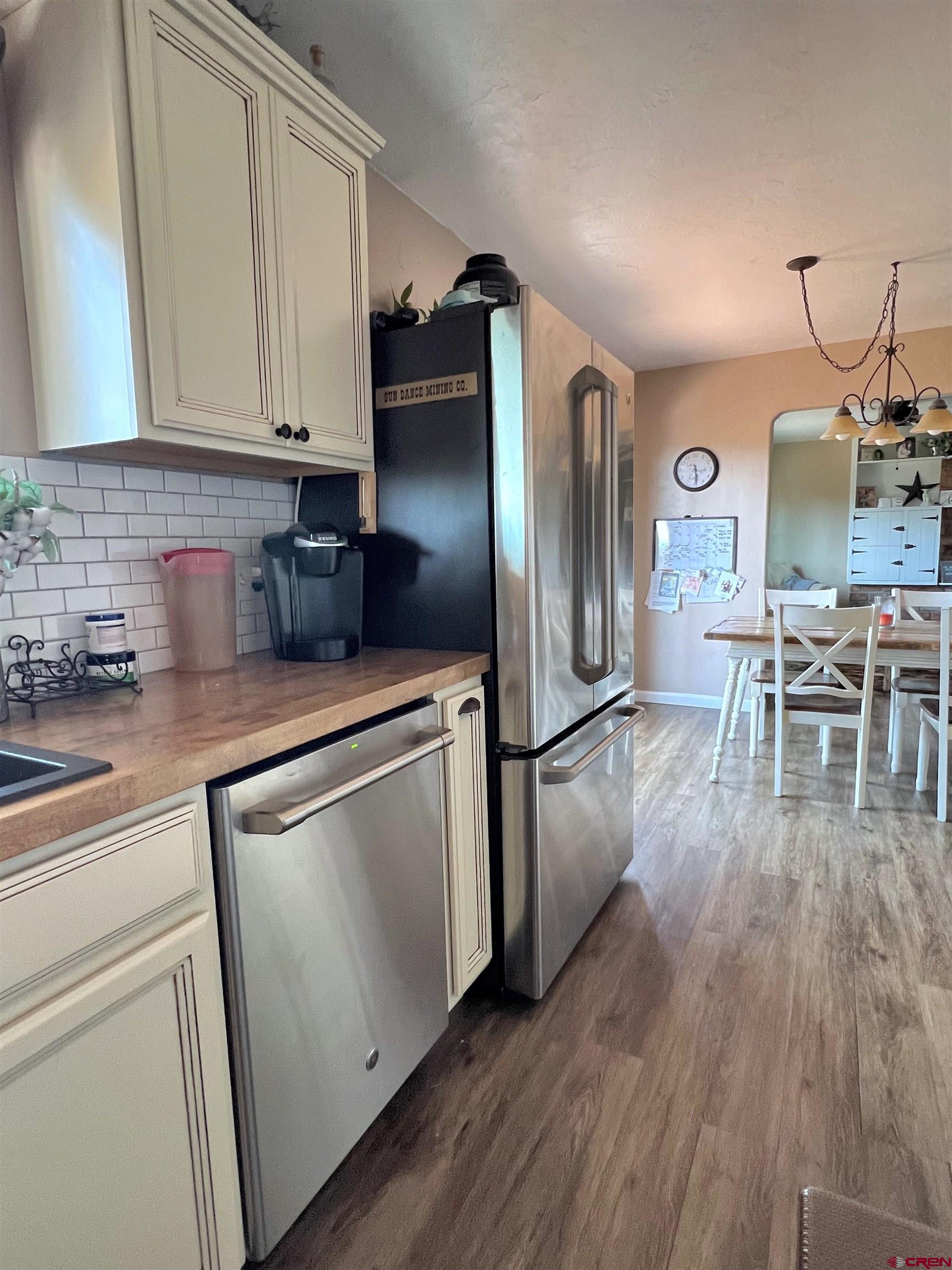 7571 2200th Road Delta, CO 81416 - Photo 14 of 35 a kitchen with stainless steel appliances granite countertop a refrigerator a stove and white cabinets with wooden floors