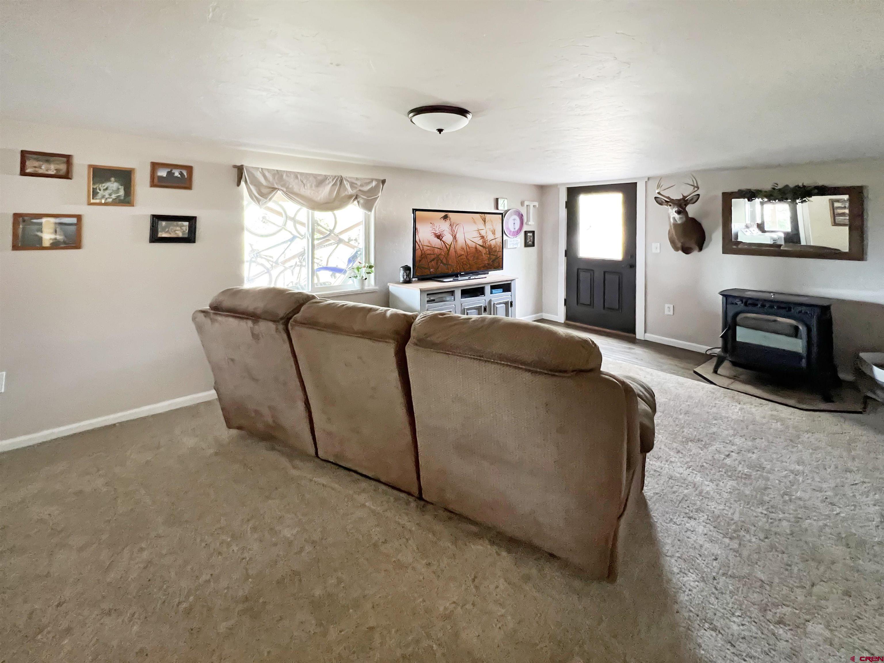 7571 2200th Road Delta, CO 81416 - Photo 21 of 35 a living room with furniture a window and a flat screen tv