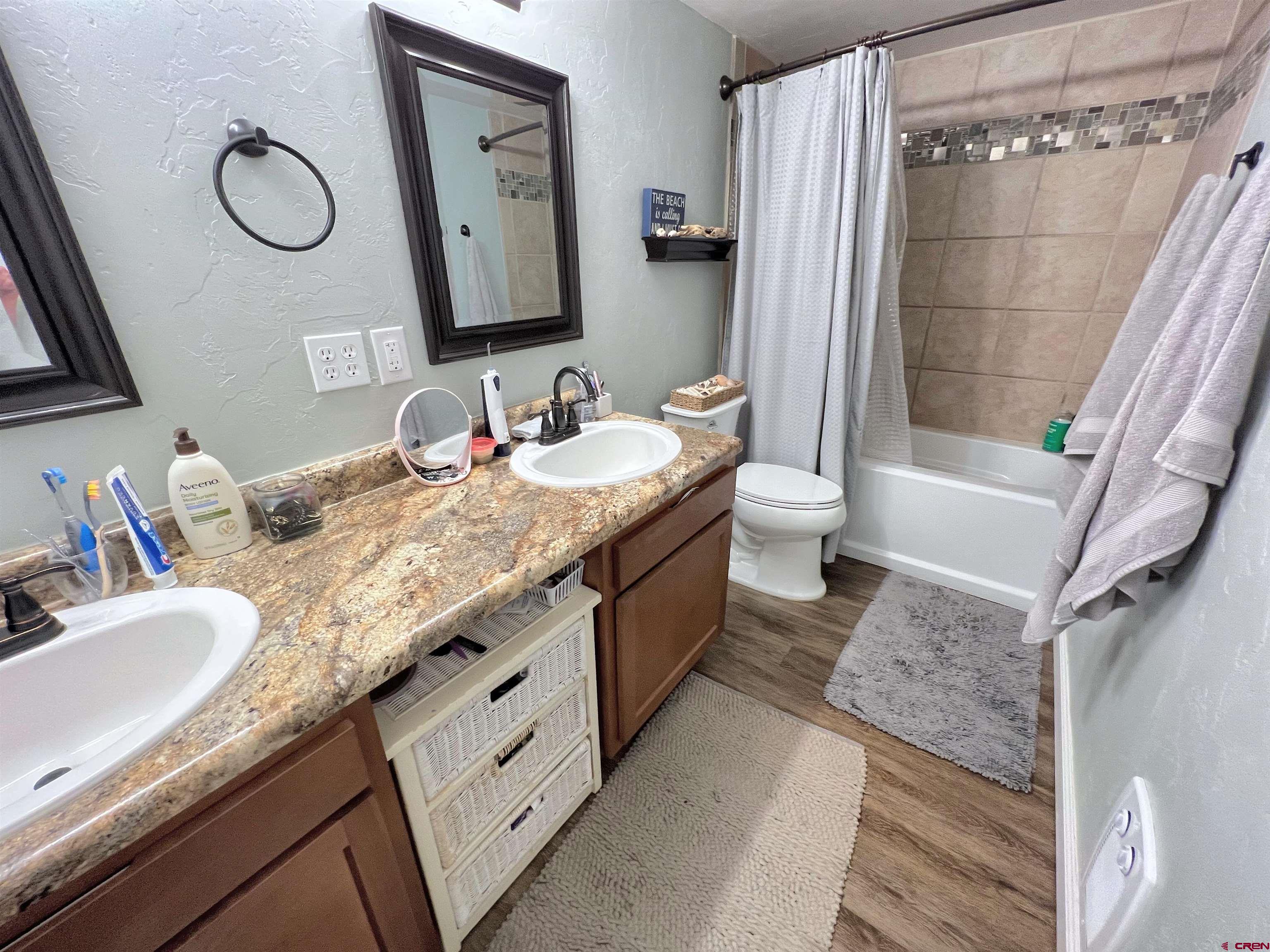7571 2200th Road Delta, CO 81416 - Photo 23 of 35 a spacious bathroom with a granite countertop sink mirror and a bathtub