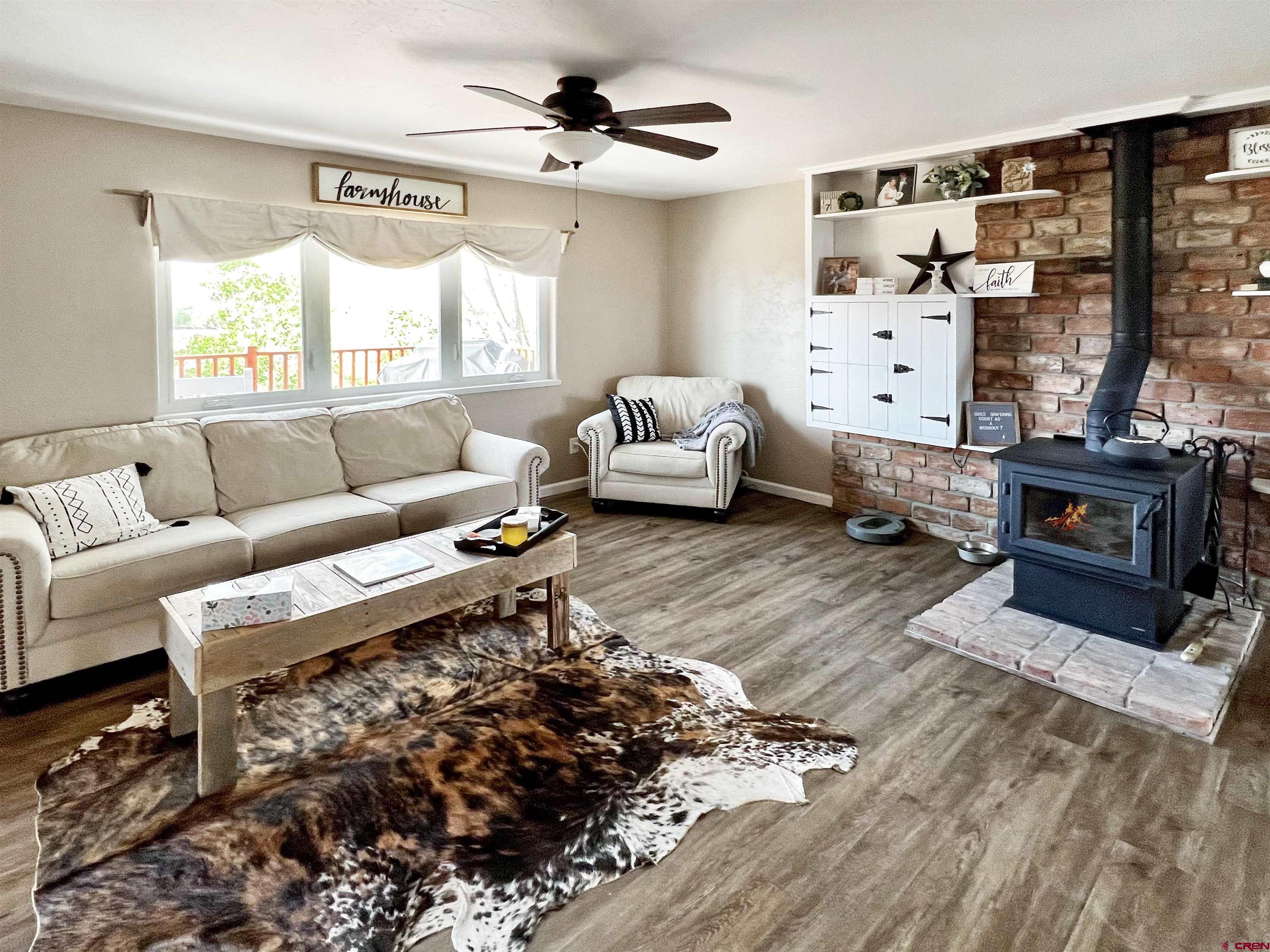 7571 2200th Road Delta, CO 81416 - Photo 6 of 35 a living room with furniture fireplace and a large window