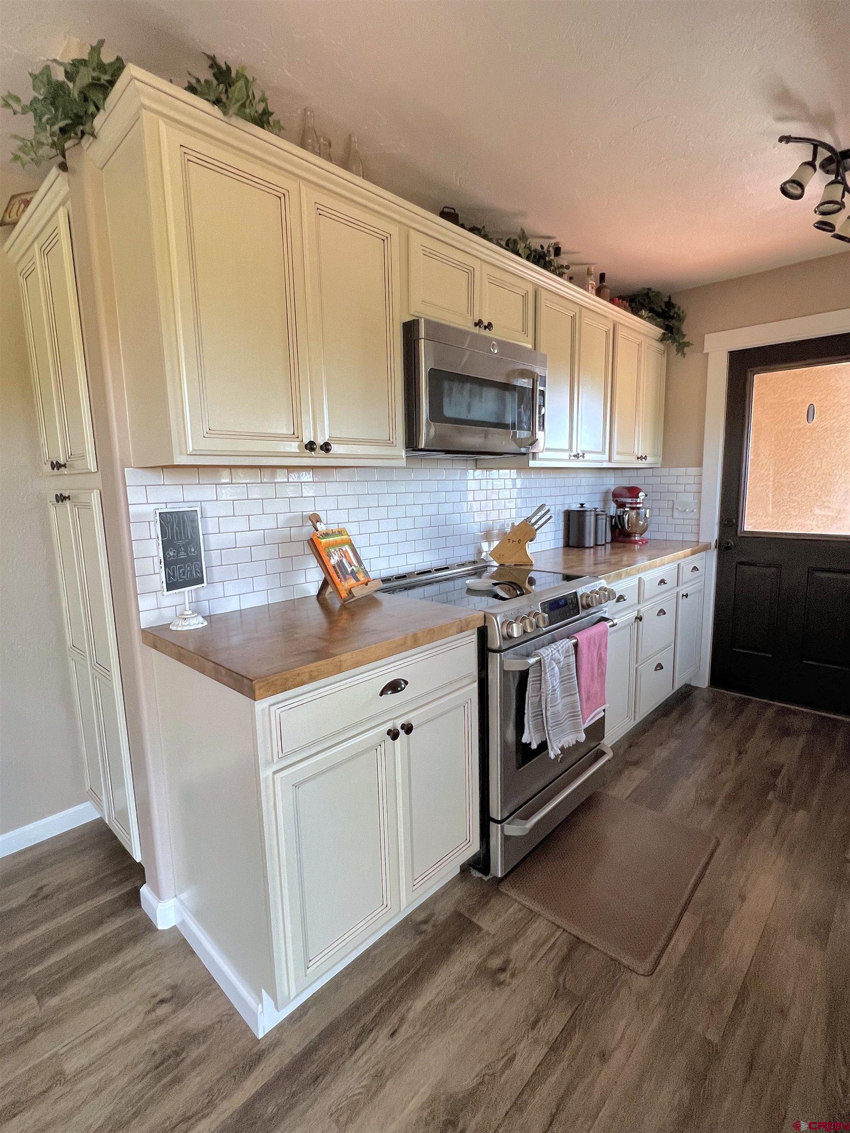 7571 2200th Road Delta, CO 81416 - Photo 10 of 35 a kitchen with stainless steel appliances granite countertop a sink stove and microwave