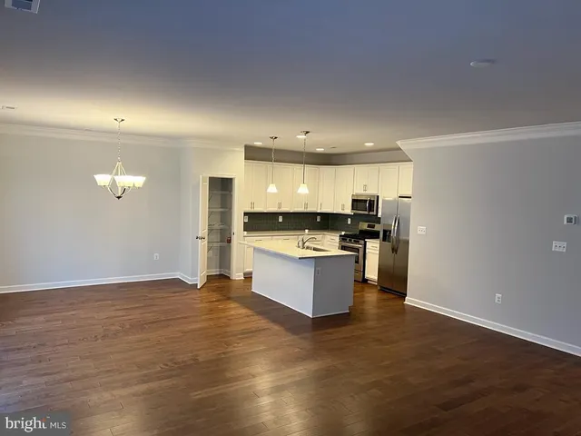 a large kitchen with a large counter top stainless steel appliances and cabinets