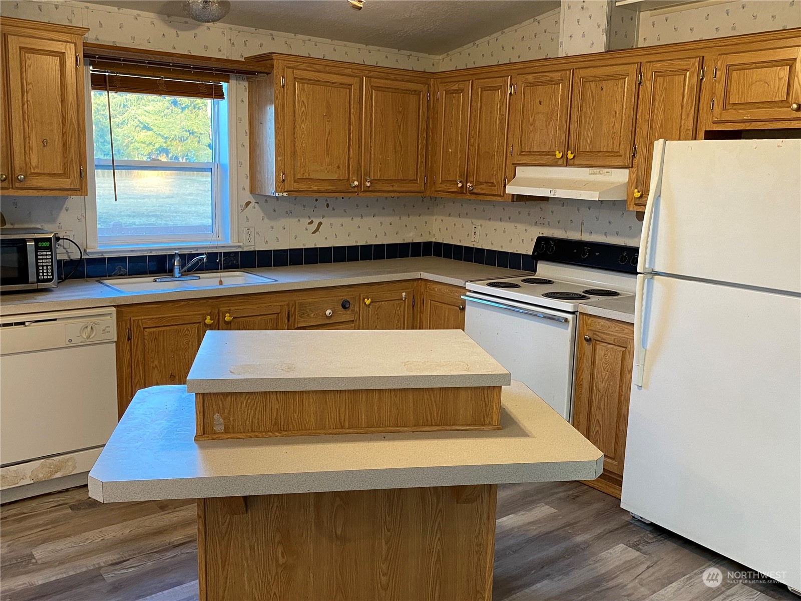 19220 Old Ranch Lane Southwest Rochester, WA 98579 - Photo 6 of 19 a kitchen with a refrigerator a stove a sink and wooden floor