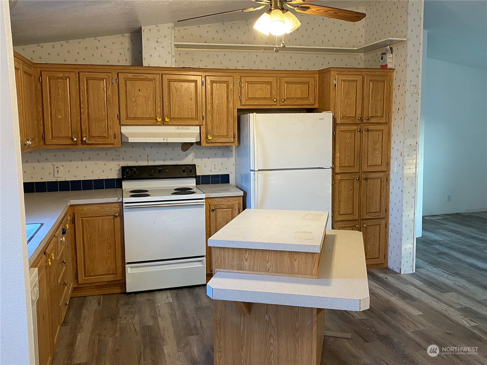 19220 Old Ranch Lane Southwest Rochester, WA 98579 - Photo 7 of 19 a kitchen with a refrigerator a stove and wooden floor