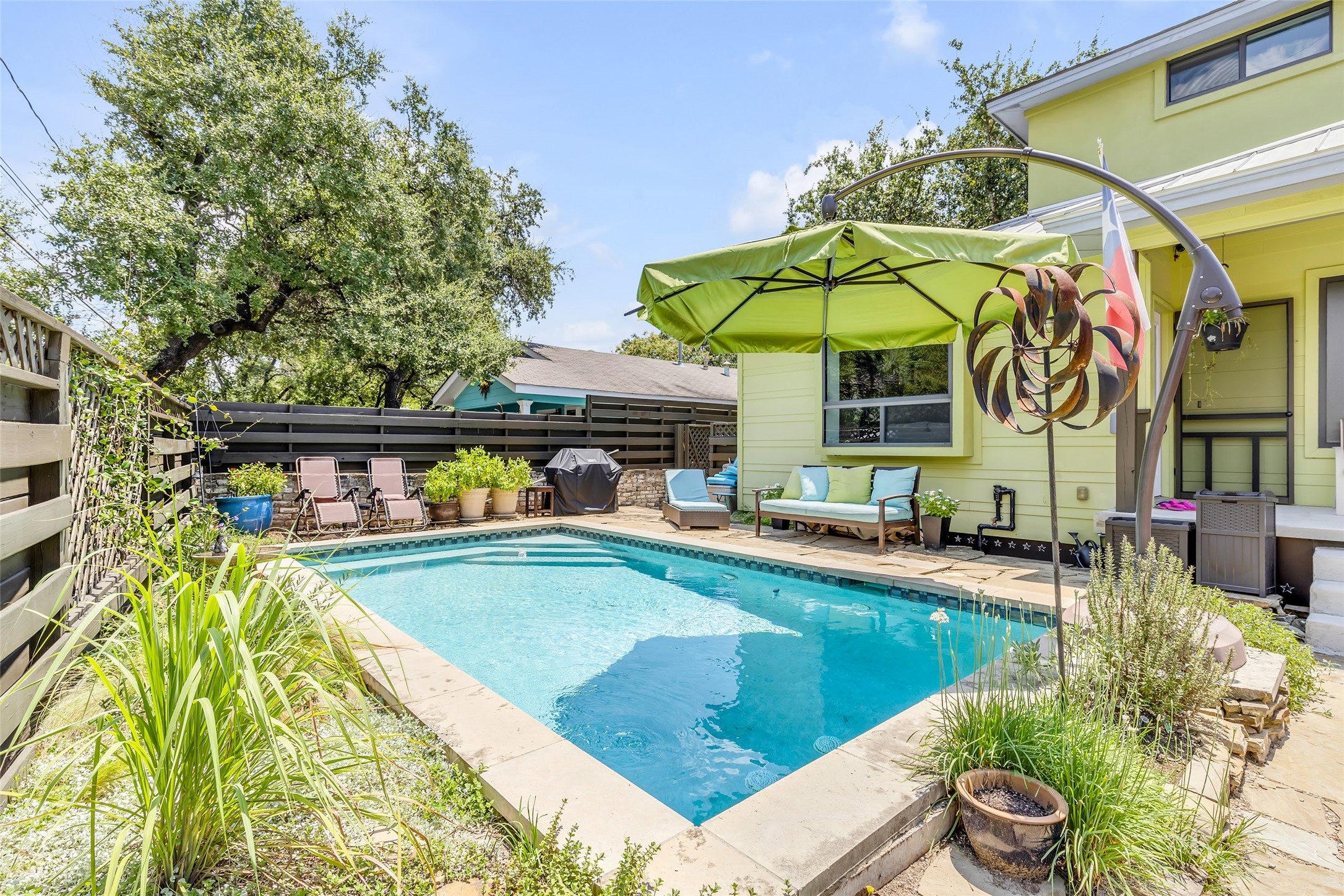 a view of a swimming pool with a lawn chairs under an umbrella