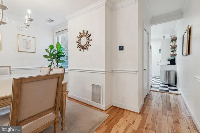 a view of a hallway with wooden floor and a potted plant