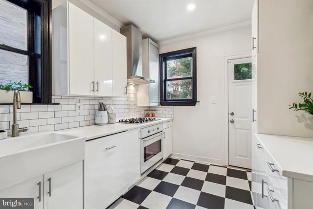 a kitchen with a sink a stove a refrigerator and a cabinets