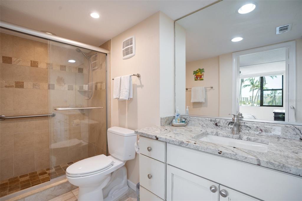 5855 Midnight Pass Road, Unit 327 Sarasota, FL 34242 - Photo 14 of 47 a bathroom with a granite countertop sink toilet and shower