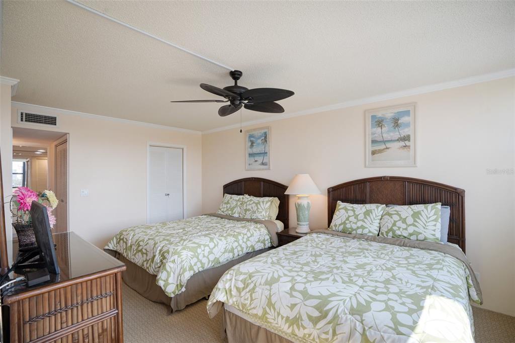 5855 Midnight Pass Road, Unit 327 Sarasota, FL 34242 - Photo 15 of 47 a bedroom with two beds and a chandelier