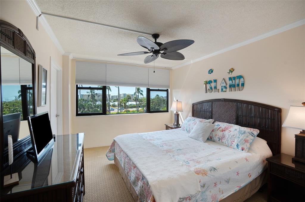 5855 Midnight Pass Road, Unit 327 Sarasota, FL 34242 - Photo 22 of 47 a bedroom with a bed and a flat screen tv