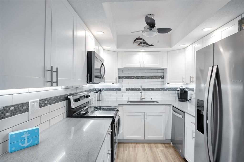5855 Midnight Pass Road, Unit 327 Sarasota, FL 34242 - Photo 4 of 47 a kitchen with a sink stainless steel appliances a counter space and cabinets