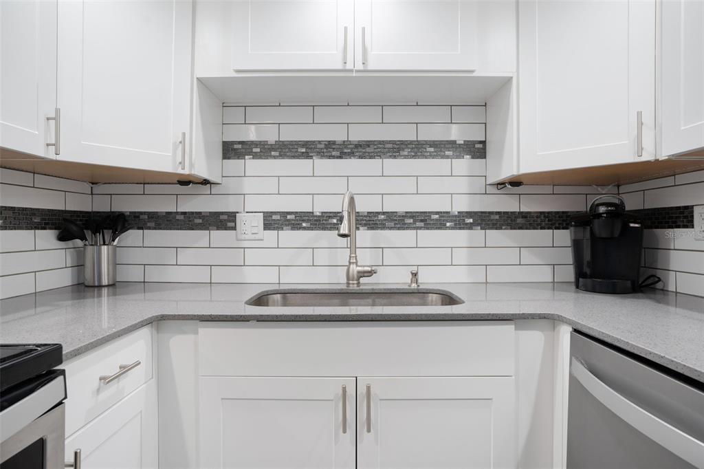 5855 Midnight Pass Road, Unit 327 Sarasota, FL 34242 - Photo 5 of 47 a kitchen with kitchen island a sink counter top space and cabinets