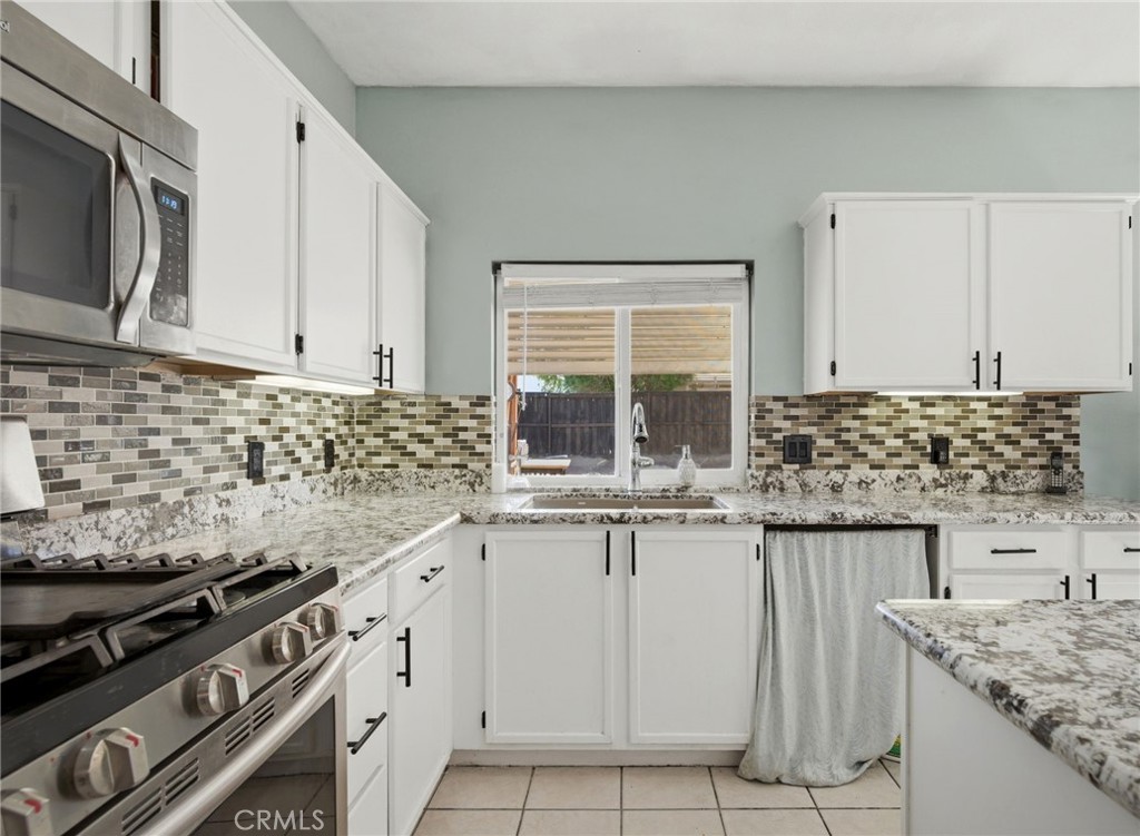 1853 Rue Chablis San Jacinto, CA 92583 - Photo 11 of 27 a kitchen with granite countertop white cabinets and white appliances