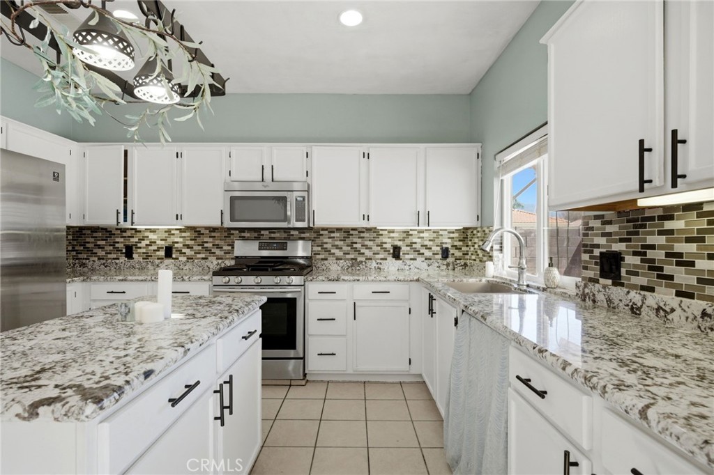 1853 Rue Chablis San Jacinto, CA 92583 - Photo 12 of 27 a kitchen with stainless steel appliances granite countertop a sink stove and cabinets
