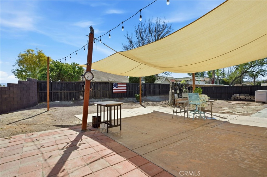 1853 Rue Chablis San Jacinto, CA 92583 - Photo 21 of 27 a view of a patio with a table chairs and a small yard