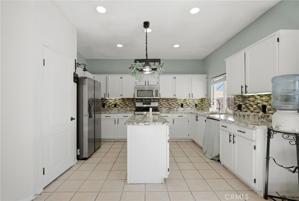 1853 Rue Chablis San Jacinto, CA 92583 - Photo 10 of 27 a kitchen with white cabinets and white appliances
