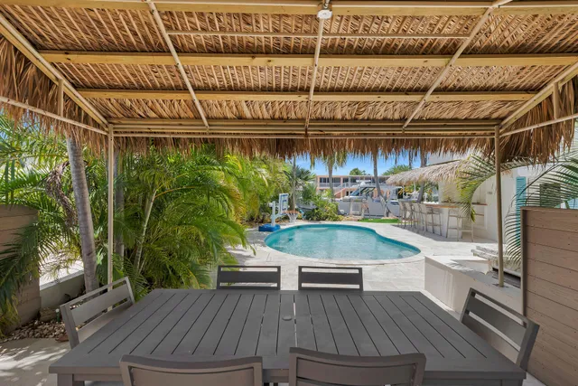 a view of a swimming pool with a lawn chairs under an umbrella