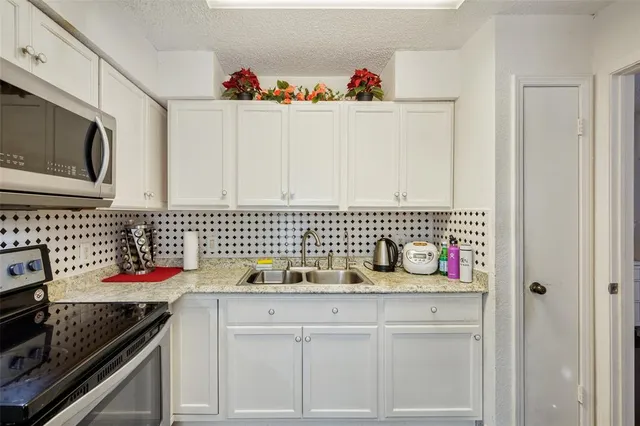 a kitchen with a sink dishwasher stove and cabinets