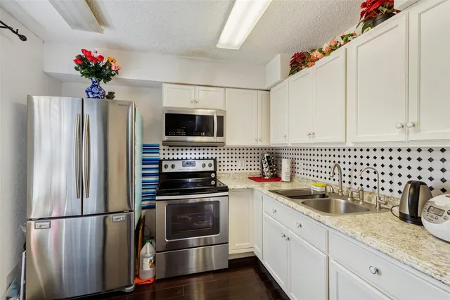 a kitchen with a refrigerator sink and cabinets