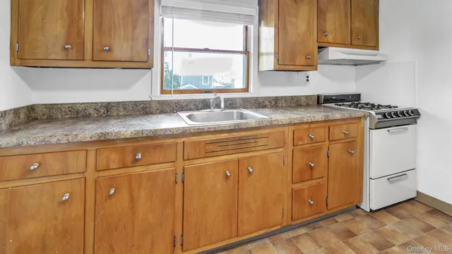 a kitchen with granite countertop cabinets stainless steel appliances a sink and a window